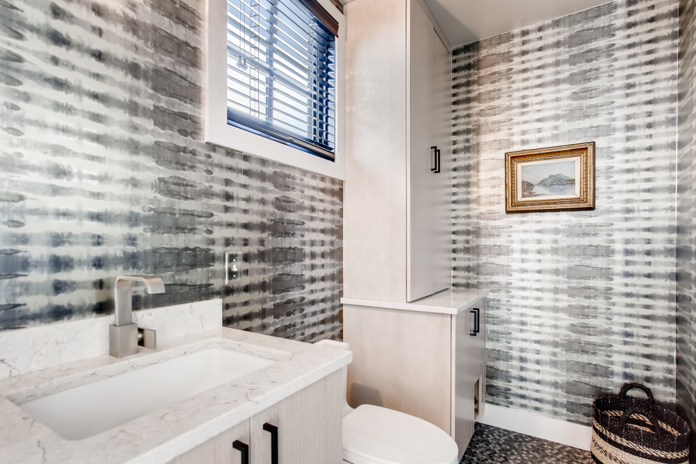 Idee per un bagno di servizio design con ante lisce, ante beige, WC monopezzo, pareti multicolore, lavabo sottopiano, pavimento multicolore, top bianco e carta da parati
