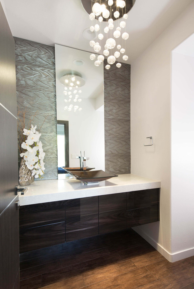 Mittelgroße Moderne Gästetoilette mit flächenbündigen Schrankfronten, dunklen Holzschränken, weißer Wandfarbe, braunem Holzboden, Aufsatzwaschbecken, Quarzwerkstein-Waschtisch, braunem Boden und weißer Waschtischplatte in Los Angeles