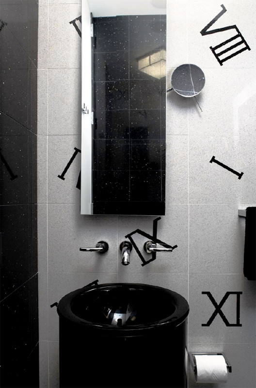 Inspiration for an expansive modern cloakroom in New York with a one-piece toilet, black and white tiles, stone tiles, white walls and a pedestal sink.