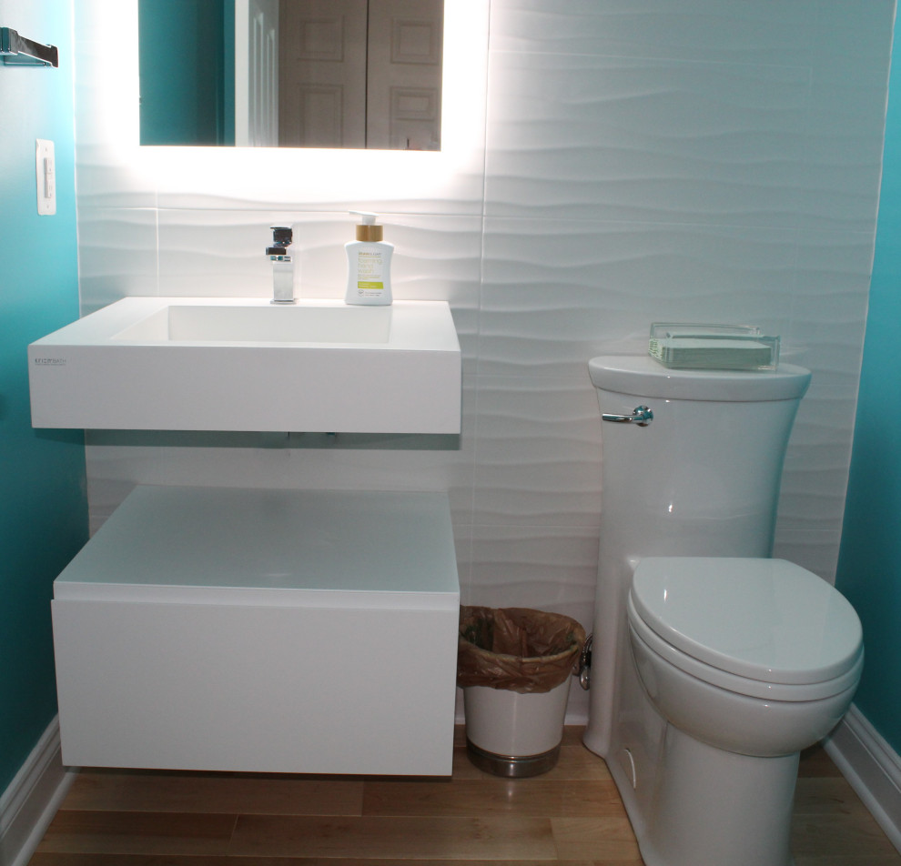 Réalisation d'un petit WC et toilettes design avec un carrelage blanc, des carreaux de céramique et parquet clair.