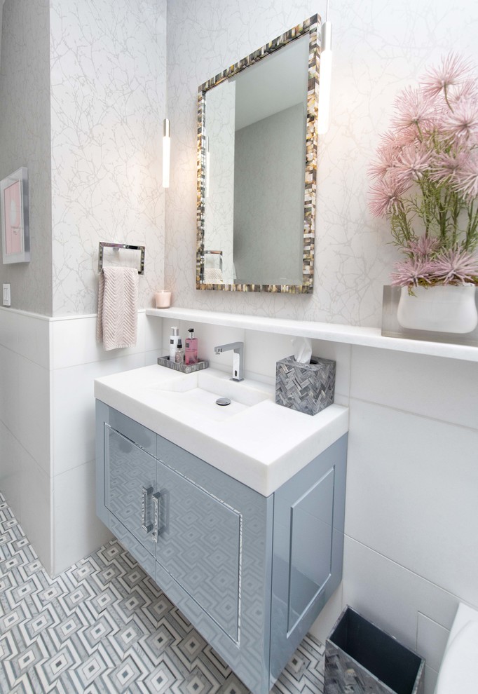 Идея дизайна: туалет среднего размера в стиле неоклассика (современная классика) с плоскими фасадами, серыми фасадами, инсталляцией, белой плиткой, мраморной плиткой, серыми стенами, полом из мозаичной плитки, монолитной раковиной, мраморной столешницей, разноцветным полом и белой столешницей