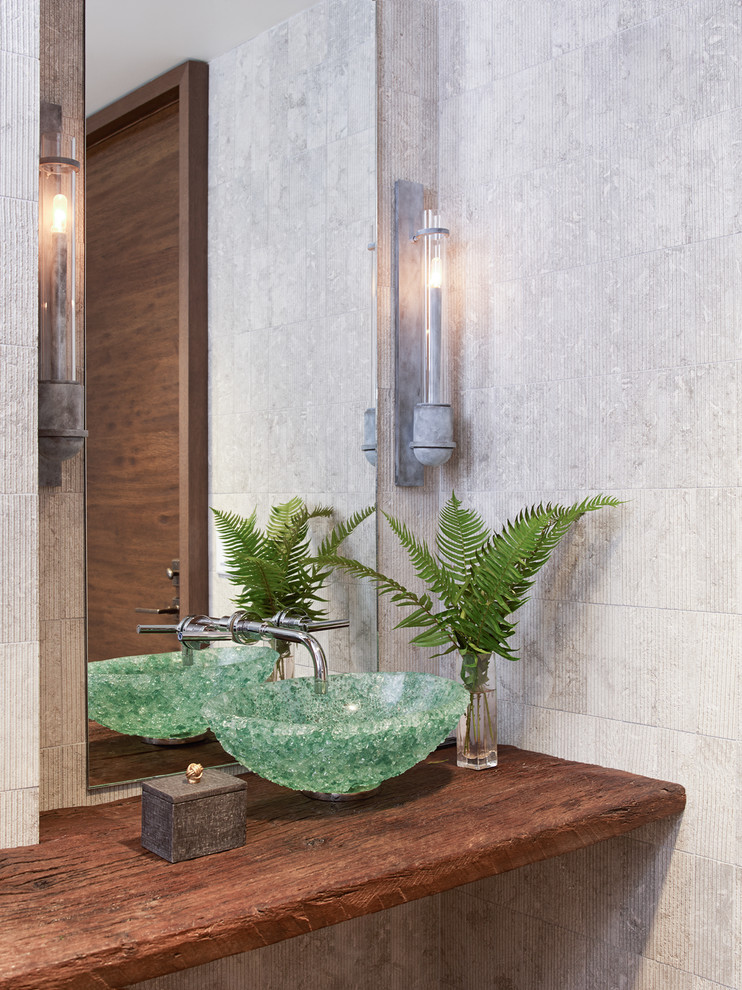 Moderne Gästetoilette mit grauen Fliesen, Aufsatzwaschbecken, Waschtisch aus Holz und brauner Waschtischplatte in Houston