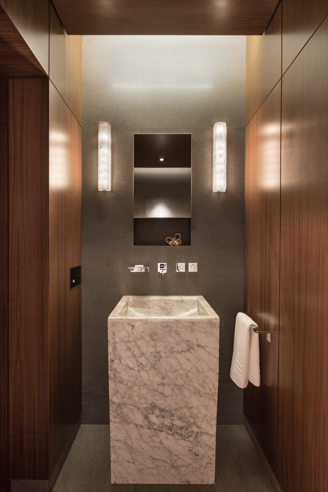 Example of a mid-sized minimalist gray tile powder room design in New York with a pedestal sink