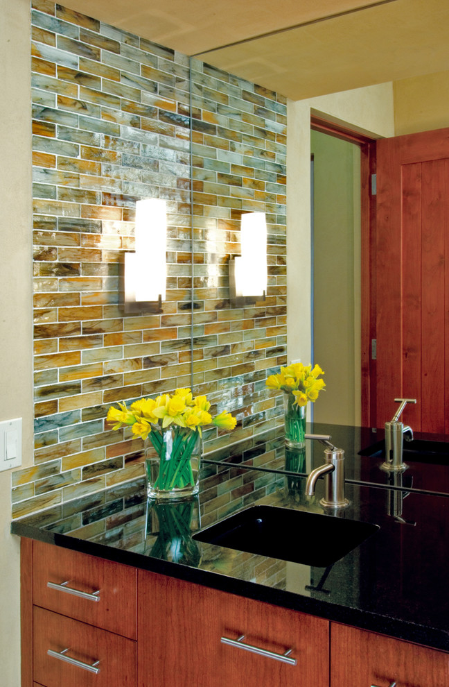 Photo of a medium sized modern cloakroom in Albuquerque with a submerged sink, flat-panel cabinets, medium wood cabinets, granite worktops, multi-coloured tiles and glass tiles.