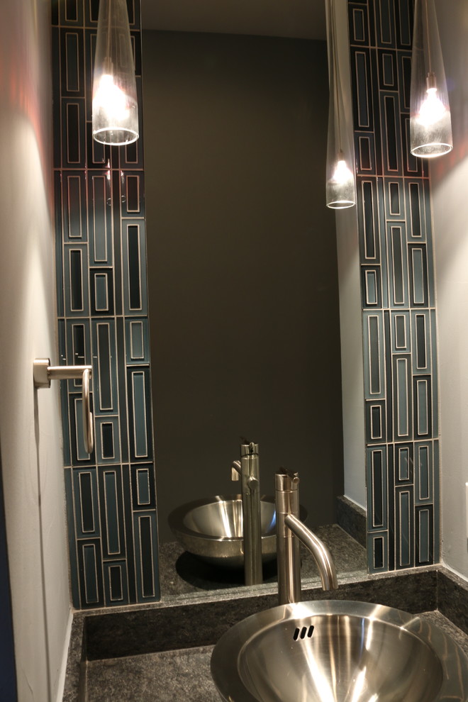 Bild på ett litet funkis toalett, med blå kakel, glaskakel, grå väggar, ett fristående handfat och granitbänkskiva