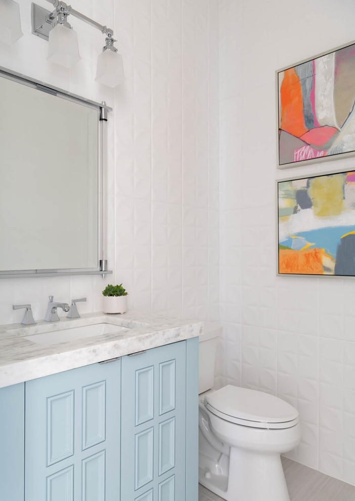 Réalisation d'un petit WC et toilettes tradition avec des portes de placard bleues, WC à poser, un mur blanc, un plan de toilette blanc et meuble-lavabo sur pied.