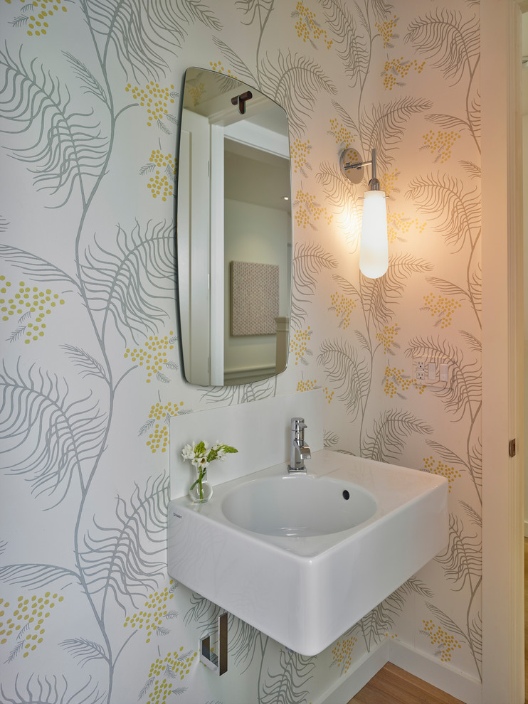 Inspiration för små klassiska toaletter, med ljust trägolv, ett väggmonterat handfat, en vägghängd toalettstol, flerfärgade väggar och beiget golv