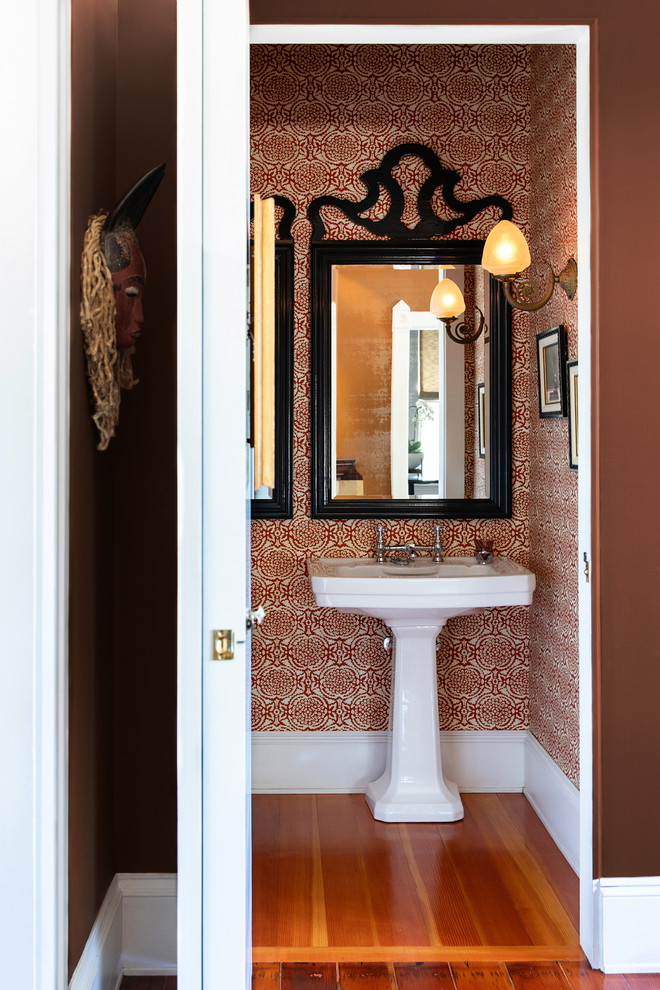 Small eclectic medium tone wood floor powder room photo in San Diego with red walls