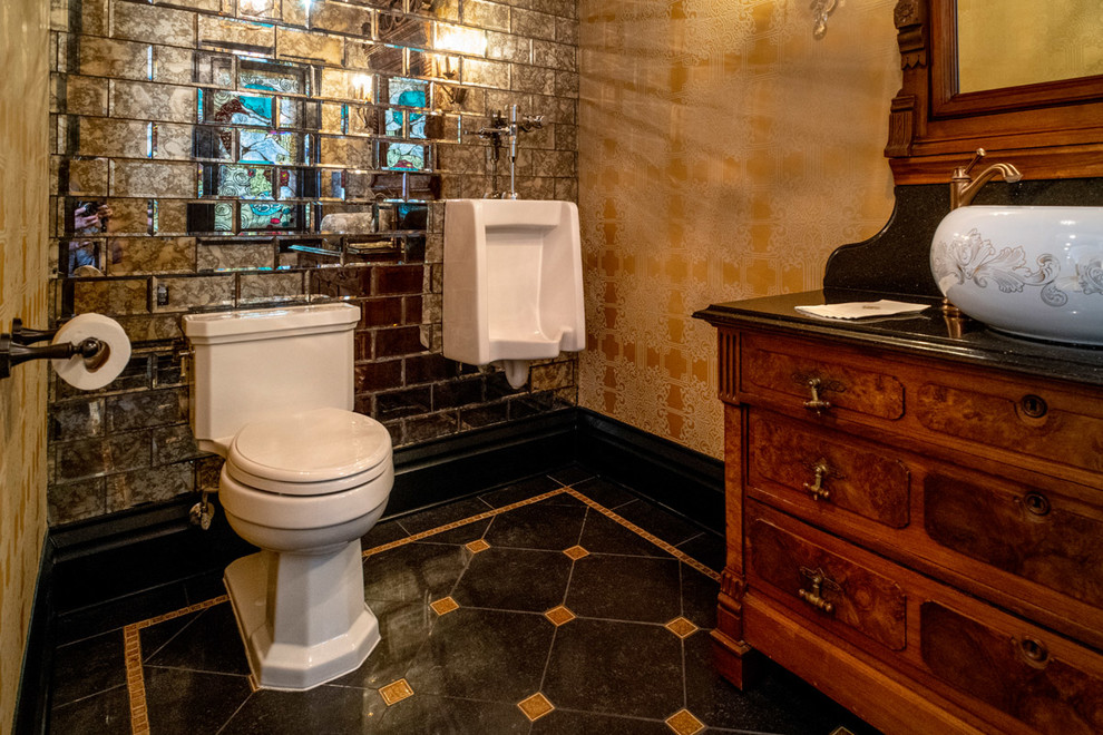 На фото: большой туалет в викторианском стиле с фасадами островного типа, светлыми деревянными фасадами, раздельным унитазом, зеркальной плиткой, желтыми стенами, полом из керамогранита, настольной раковиной, мраморной столешницей, черным полом и черной столешницей с