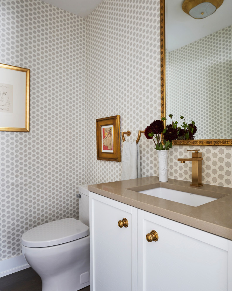 Inspiration for a transitional brown floor and wallpaper powder room remodel in Chicago with white cabinets, a one-piece toilet and gray countertops