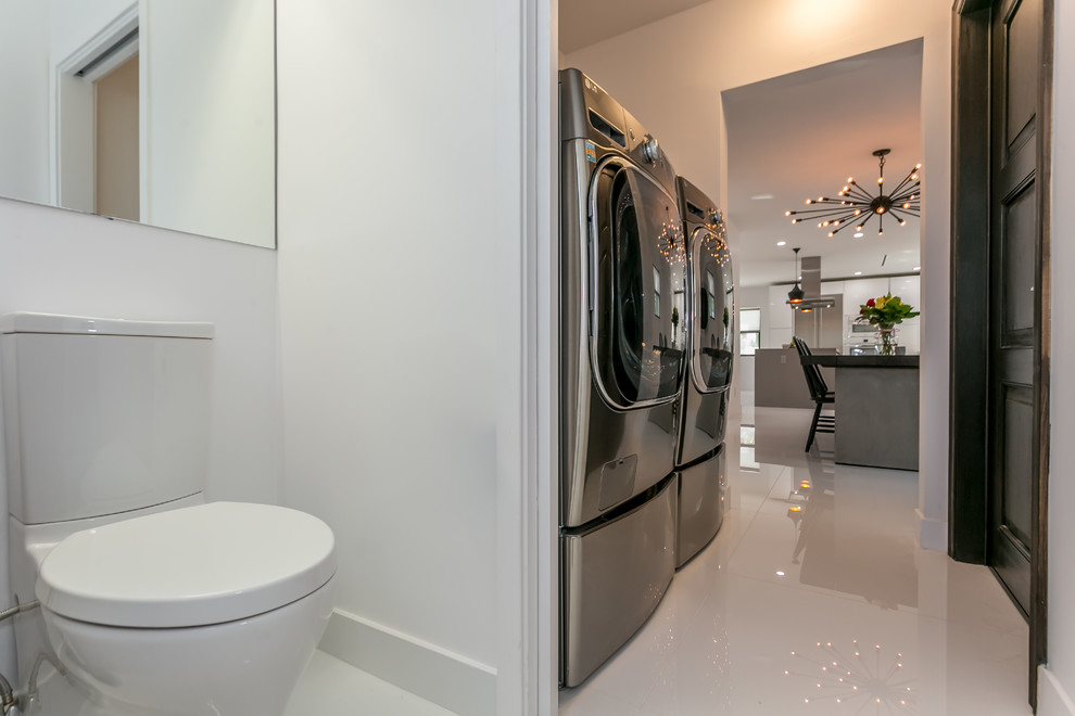 Foto di un piccolo bagno di servizio minimalista con pareti bianche, pavimento in gres porcellanato, lavabo integrato e top in quarzo composito