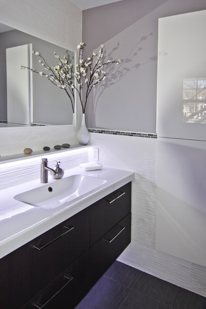 Esempio di un piccolo bagno di servizio minimalista con lavabo integrato, ante lisce, ante in legno bruno, WC monopezzo, piastrelle bianche, piastrelle in ceramica, pareti grigie e pavimento in gres porcellanato