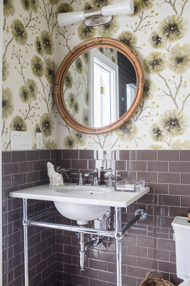 Foto di un bagno di servizio stile marinaro con piastrelle marroni, piastrelle di vetro, pareti multicolore, lavabo sottopiano e top bianco