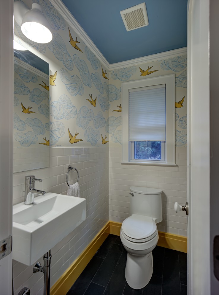Cette photo montre un petit WC et toilettes moderne avec un lavabo suspendu, un carrelage blanc, un mur multicolore, WC à poser et un carrelage métro.