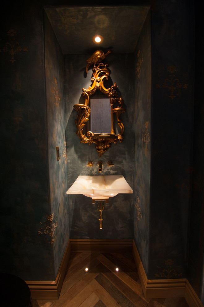 Réalisation d'un WC et toilettes tradition de taille moyenne avec un mur bleu, un sol en bois brun, un lavabo suspendu et un sol marron.