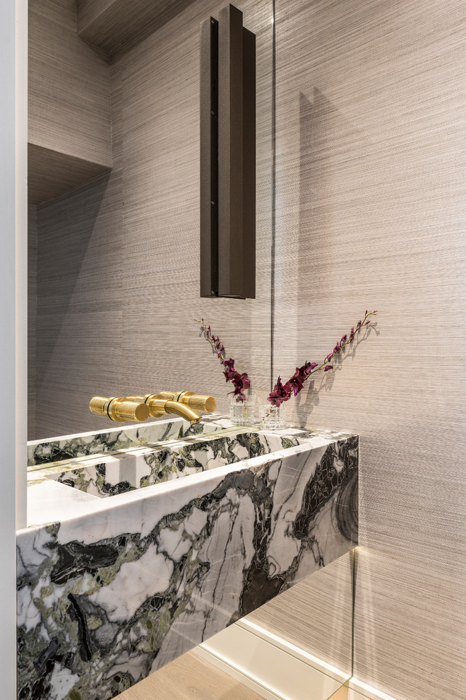 Immagine di un bagno di servizio design con pareti beige, lavabo integrato e top multicolore