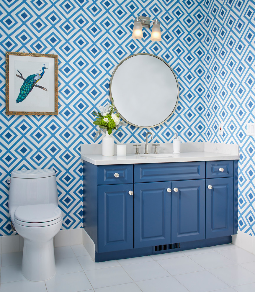 На фото: туалет в стиле неоклассика (современная классика) с фасадами с выступающей филенкой, синими фасадами, унитазом-моноблоком, синими стенами, врезной раковиной и белым полом
