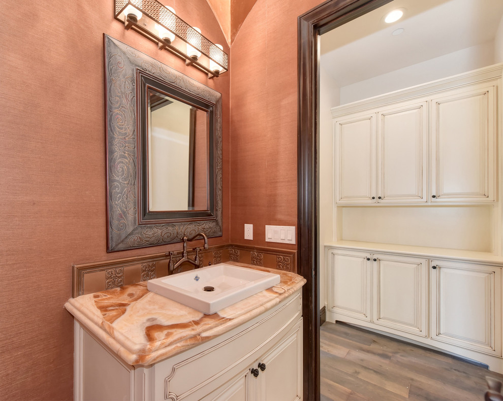 Idéer för ett mellanstort klassiskt beige toalett, med luckor med upphöjd panel, vita skåp, brun kakel, kakel i metall, orange väggar, mellanmörkt trägolv, ett fristående handfat, bänkskiva i kvarts och brunt golv
