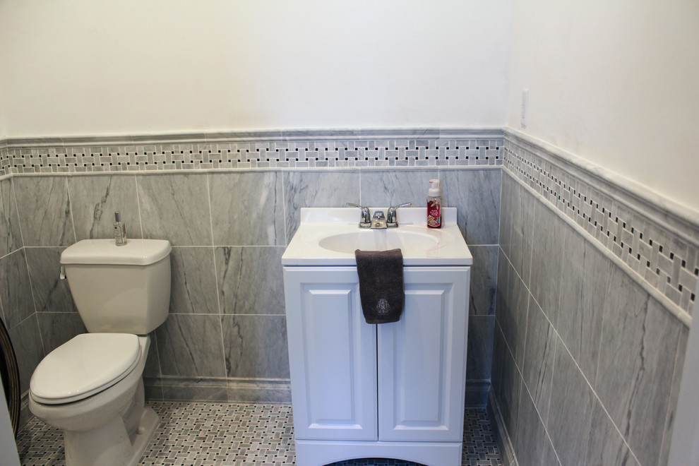 Réalisation d'un WC et toilettes tradition avec un placard avec porte à panneau surélevé, des portes de placard blanches, WC séparés, un carrelage gris, un carrelage blanc, un carrelage de pierre, un mur blanc, un sol en marbre et un lavabo intégré.