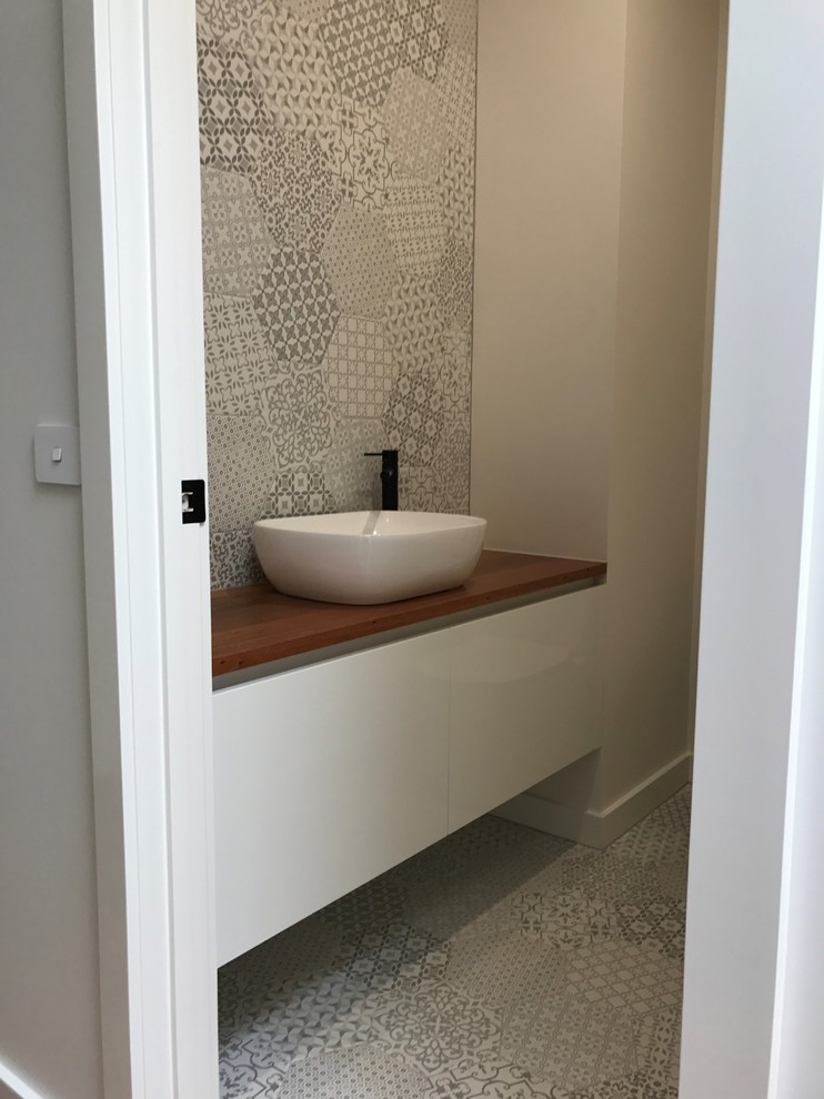 Ejemplo de aseo minimalista pequeño con puertas de armario blancas, paredes blancas, lavabo sobreencimera, encimera de madera y encimeras marrones