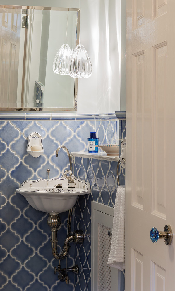 Foto på ett litet vintage toalett, med blå kakel, keramikplattor, vita väggar och ett väggmonterat handfat