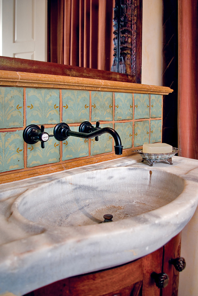 Immagine di un piccolo bagno di servizio mediterraneo con lavabo integrato, consolle stile comò, ante in legno scuro, top in marmo, piastrelle verdi, piastrelle in terracotta e pareti beige