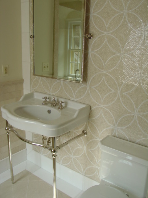 Bild på ett litet maritimt toalett, med en toalettstol med separat cisternkåpa, mosaik, flerfärgade väggar, ett piedestal handfat och beiget golv