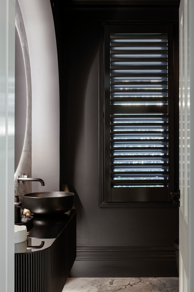 Inspiration for a small modern cloakroom in Sydney with raised-panel cabinets, black cabinets, a wall mounted toilet, black tiles, ceramic tiles, black walls, marble flooring, a vessel sink, glass worktops, grey floors, black worktops and a floating vanity unit.