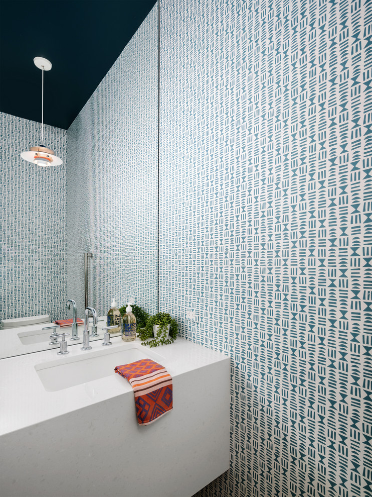 Imagen de aseo actual con paredes multicolor, lavabo bajoencimera y encimeras blancas