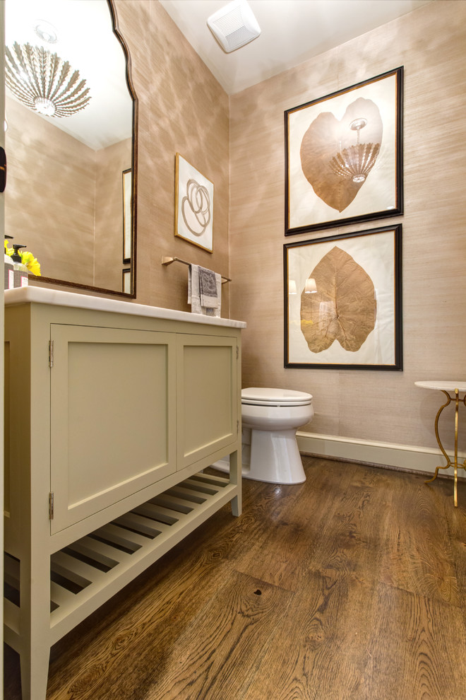 Idéer för att renovera ett mellanstort vintage vit vitt toalett, med luckor med infälld panel, beige skåp, en toalettstol med separat cisternkåpa, beige väggar, mörkt trägolv, ett undermonterad handfat, marmorbänkskiva och brunt golv