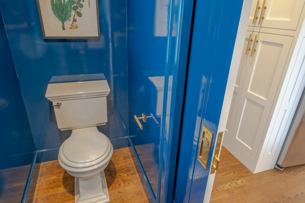 На фото: маленький туалет в классическом стиле с открытыми фасадами, белыми фасадами, раздельным унитазом, синими стенами, паркетным полом среднего тона, врезной раковиной, мраморной столешницей, коричневым полом и белой столешницей для на участке и в саду