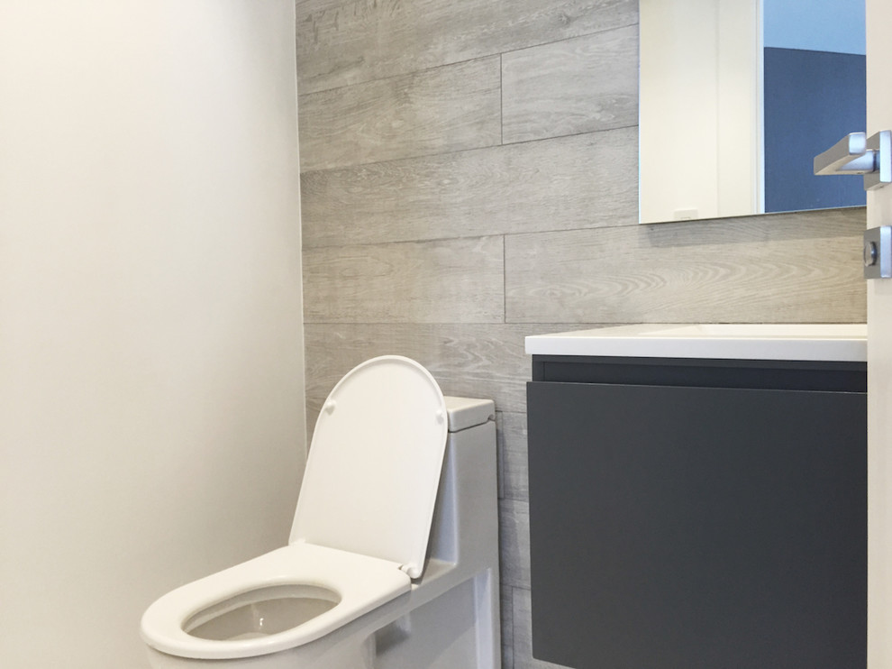 Mittelgroße Moderne Gästetoilette mit flächenbündigen Schrankfronten, grauen Schränken, grauen Fliesen, Porzellan-Bodenfliesen, integriertem Waschbecken und Quarzwerkstein-Waschtisch in Miami