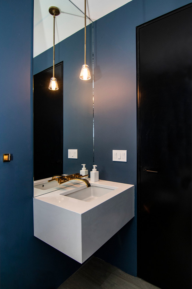 Example of a small trendy medium tone wood floor and gray floor powder room design in New York with blue walls, quartz countertops, white countertops and an undermount sink