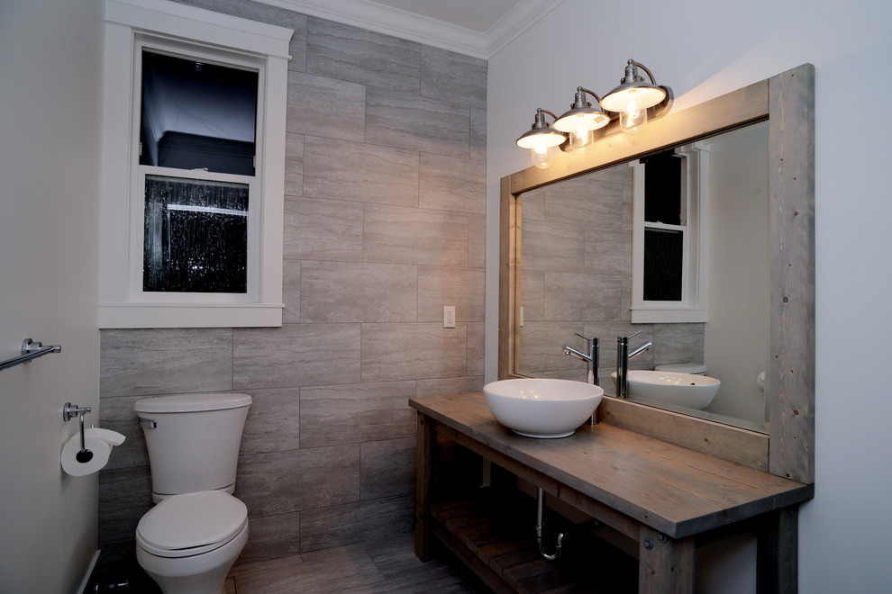 Exemple d'un grand WC et toilettes moderne en bois brun avec une vasque, un placard en trompe-l'oeil, un plan de toilette en bois, WC séparés, un carrelage gris, des carreaux de porcelaine, un mur blanc, un sol en carrelage de porcelaine et un sol gris.