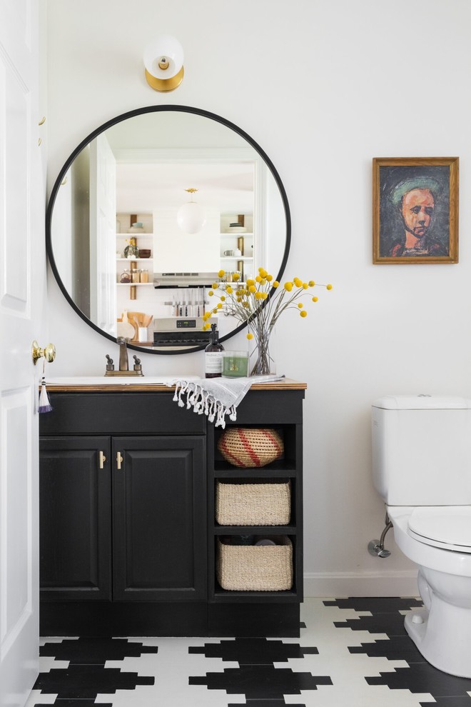 ボストンにあるエクレクティックスタイルのおしゃれなトイレ・洗面所 (レイズドパネル扉のキャビネット、黒いキャビネット、白い壁、オーバーカウンターシンク、マルチカラーの床) の写真