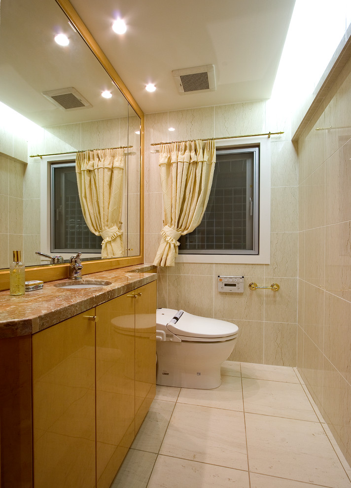 Idéer för att renovera ett funkis brun brunt toalett, med släta luckor, bruna skåp, beige väggar, ett integrerad handfat och beiget golv