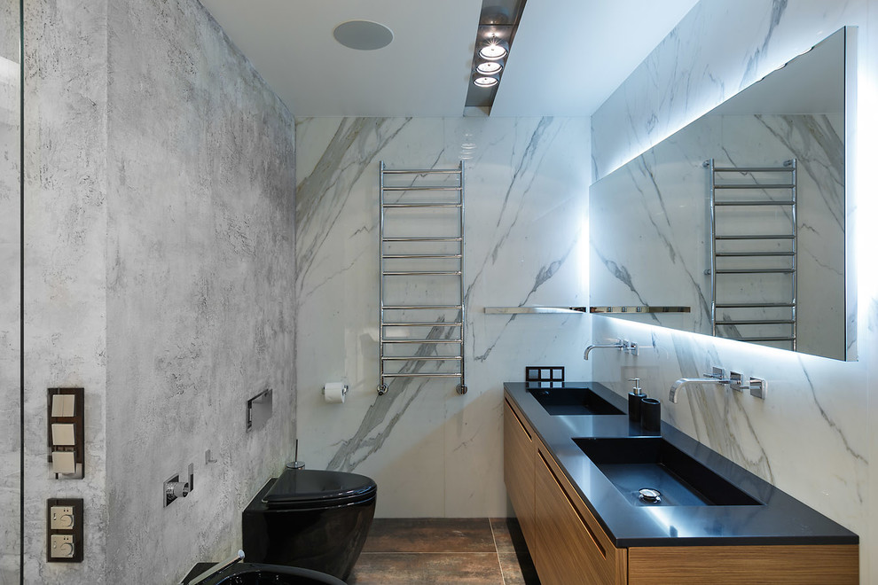 Immagine di un bagno di servizio bohémian con ante lisce, ante in legno scuro, WC a due pezzi, pareti grigie e lavabo integrato