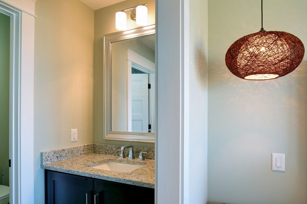 Immagine di un bagno di servizio minimal di medie dimensioni con ante in stile shaker, ante nere, pareti beige, lavabo sottopiano e top in granito
