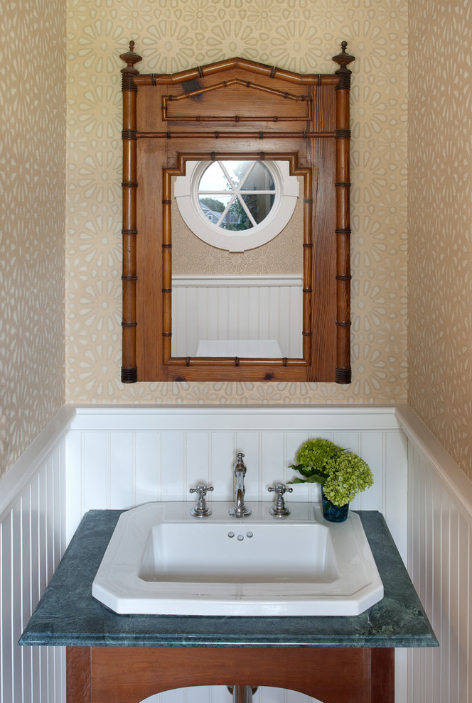 Idee per un bagno di servizio stile marino con lavabo da incasso, consolle stile comò, ante in legno scuro, pareti beige e top blu