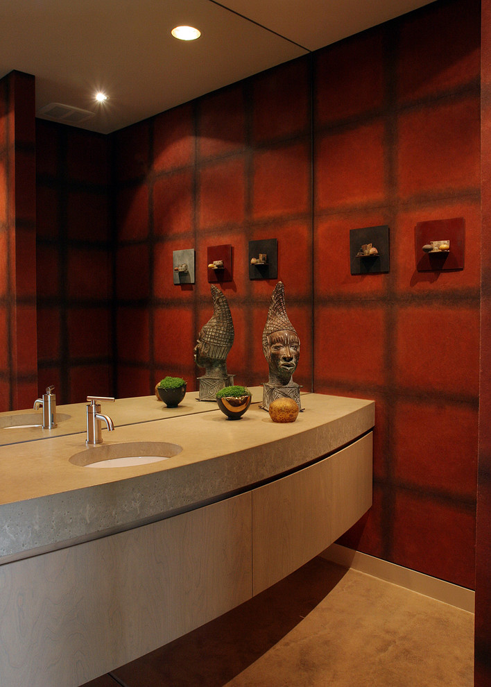 Idee per un bagno di servizio contemporaneo di medie dimensioni con WC sospeso, pareti rosse, pavimento in cemento, lavabo sottopiano, top in pietra calcarea, pavimento beige, ante lisce e ante beige