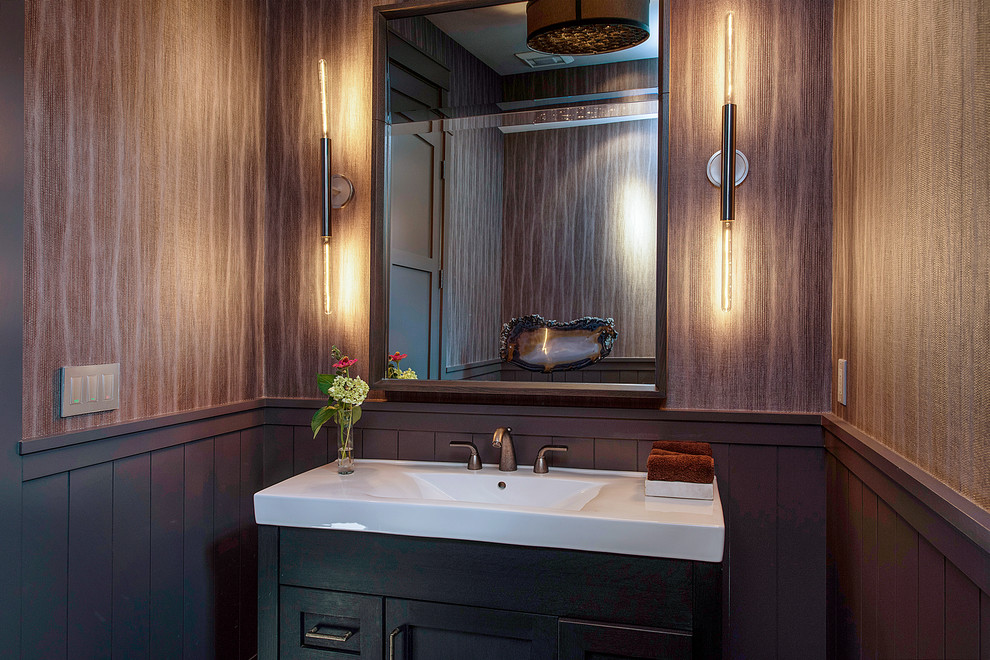 Example of a small country dark wood floor and brown floor powder room design in San Francisco with shaker cabinets, black cabinets, multicolored walls, an integrated sink and solid surface countertops