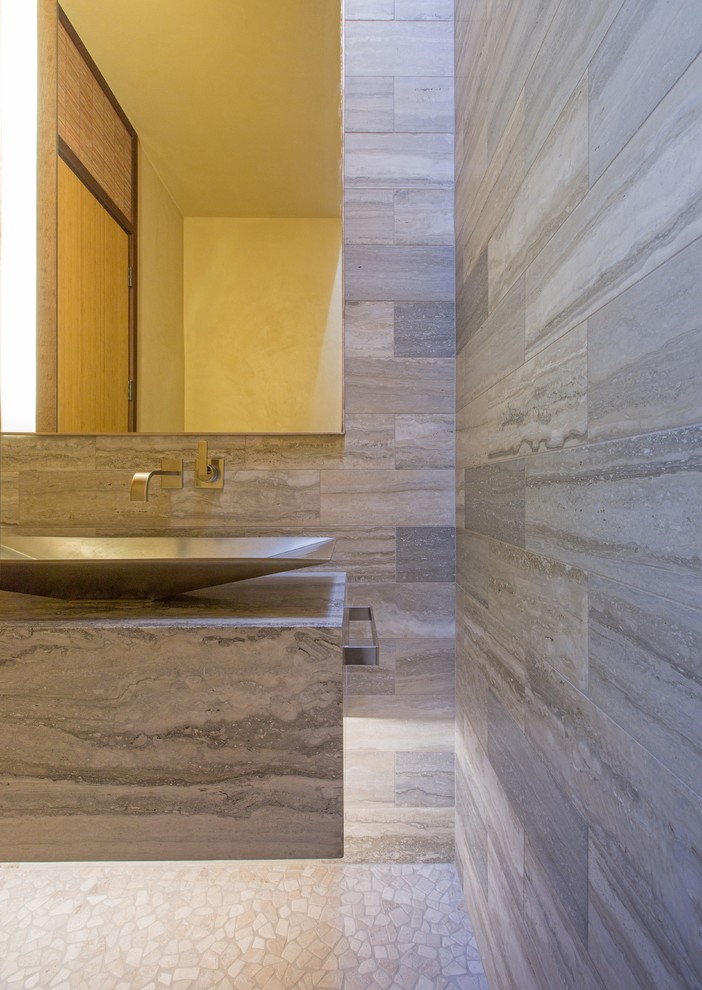 Idee per un piccolo bagno di servizio minimal con pareti grigie, pavimento con piastrelle di ciottoli, lavabo a bacinella e piastrelle in travertino