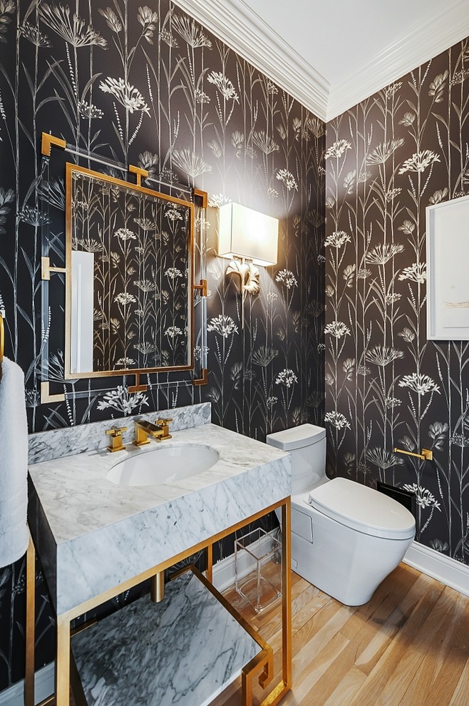 Immagine di un bagno di servizio chic con pareti nere, pavimento in legno massello medio, lavabo sottopiano, pavimento marrone e top bianco