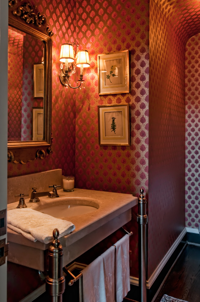 Diseño de aseo clásico renovado de tamaño medio con lavabo bajoencimera, armarios tipo mueble, encimera de granito, sanitario de una pieza, paredes rojas y suelo de madera oscura