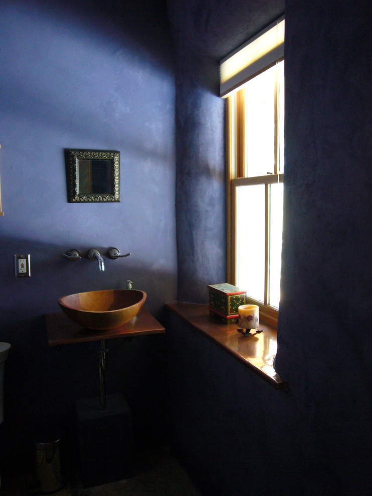 Bild på ett litet rustikt toalett, med bänkskiva i koppar och ett fristående handfat