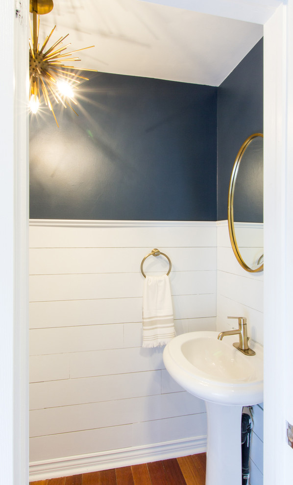 Inspiration for a small nautical cloakroom in Other with a two-piece toilet, blue walls, bamboo flooring, a pedestal sink and brown floors.