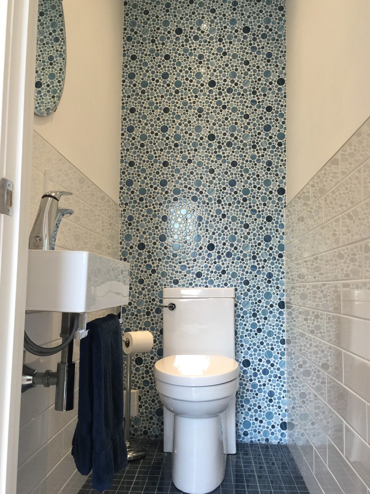 Aménagement d'un petit WC et toilettes classique avec WC à poser, un carrelage bleu, des carreaux de porcelaine, un mur blanc, un sol en carrelage de porcelaine et un lavabo suspendu.