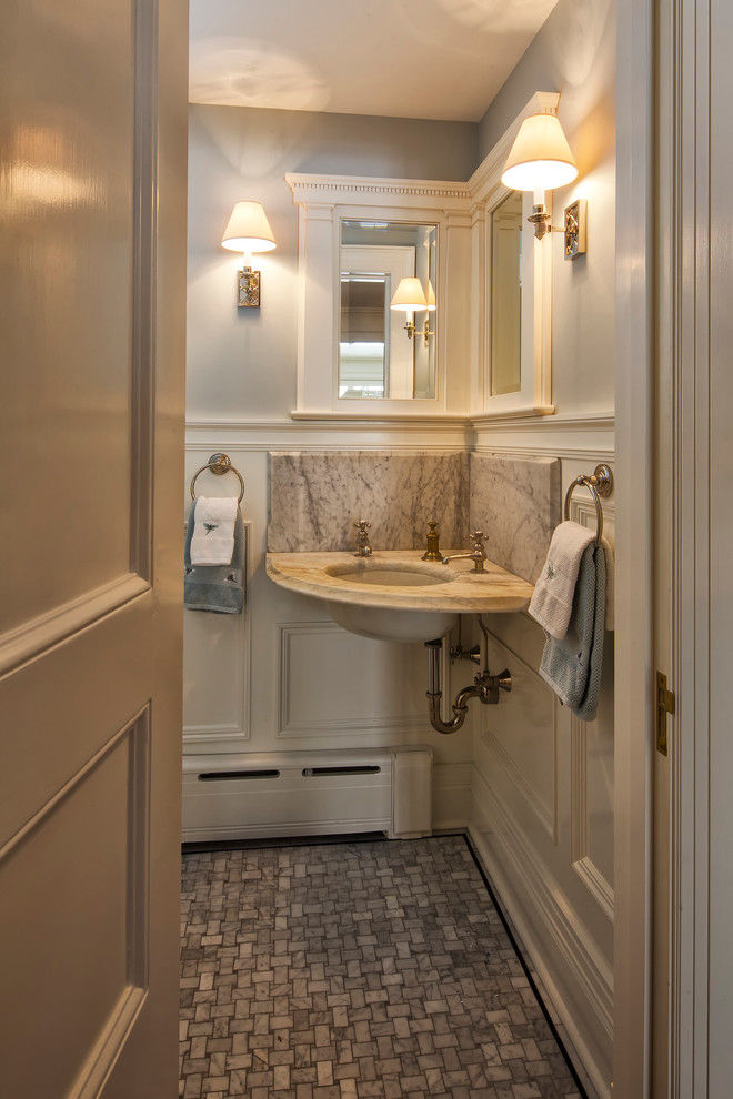 Klassische Gästetoilette mit Toilette mit Aufsatzspülkasten, blauer Wandfarbe, Marmorboden, Wandwaschbecken, Marmor-Waschbecken/Waschtisch und grauem Boden in New York