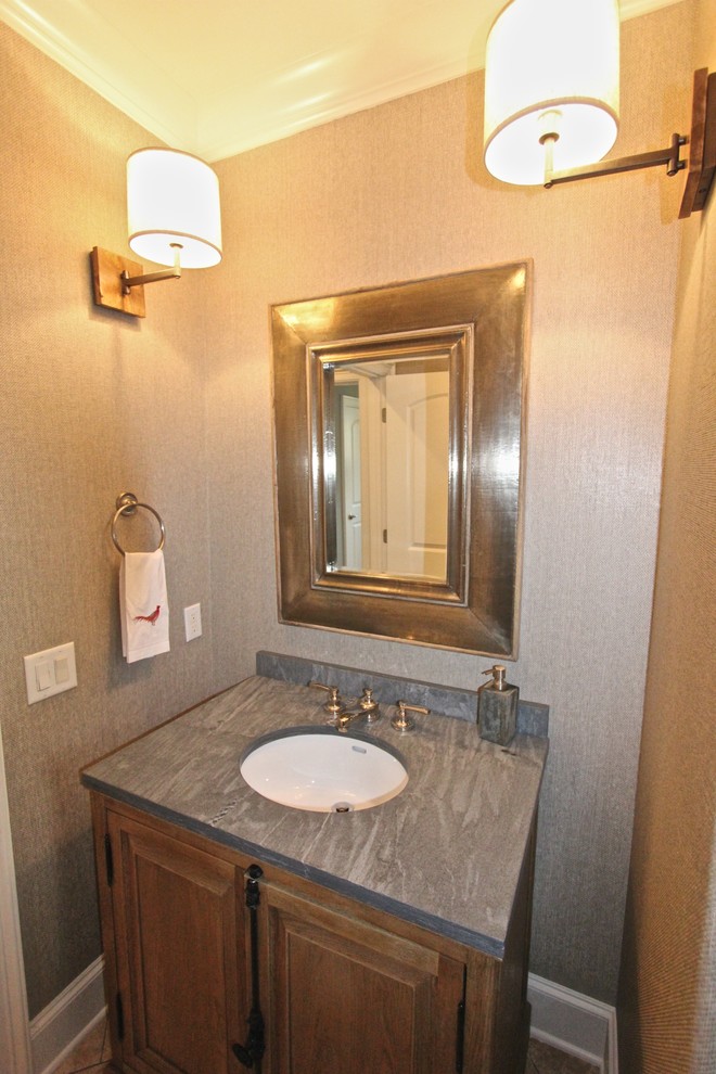 Cette image montre un petit WC et toilettes minimaliste en bois brun avec un lavabo encastré, un placard avec porte à panneau surélevé, un plan de toilette en stéatite, WC séparés, un mur gris et parquet foncé.
