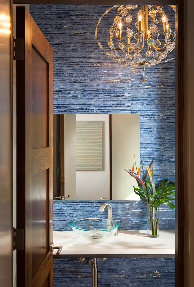Modelo de aseo de estilo americano pequeño con lavabo sobreencimera, paredes azules, encimera de acrílico y baldosas y/o azulejos azules